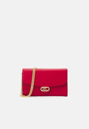 Pochette en cuir rouge avec bandoulière chaîne dorée et fermoir ovale avec logo doré à l'avant sur fond blanc.