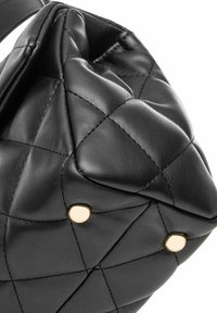 Czarna pikowana skórzana torba w kształcie zaokrąglonym, z złotymi akcentami metalowymi i gładką fakturą. Widoczne szwy.