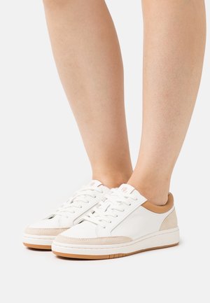 Białe skórzane sneakersy z beżowymi zamszowymi akcentami, okrągły nosek i sznurowany design. Posiadają brązowy obcas i jasnobrązową gumową podeszwę.