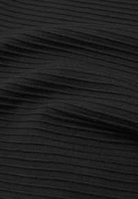 Tissu noir côtelé avec des lignes texturées horizontales et de légers plis créant des ombres et de la profondeur.