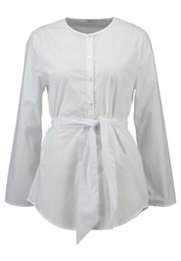 White button-up shirt with long sleeves, round neckline, tied waist, and smooth fabric texture. Features subtle buttons along the front.