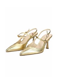 Een paar gouden slingback-hakken met spitse neus, dunne bandjes en gespen, met middelhoge naaldhakken op een witte achtergrond.