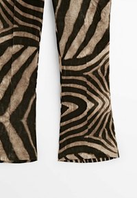 Pantalon en tissu à rayures zébrées marron et noir avec jambes larges, présenté à plat sur fond blanc.