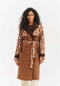 Kurteczka brązowa pikowana, dwurzędowa, z materiałem w br�ązowo-beżowe cętki na rękawach i kołnierzu.