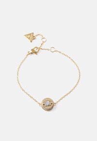 Gullkjedet bracelet med en rund anheng med en klar edelsten i midten, omkranset av små sirkulære dekorasjoner og en logo gravering.