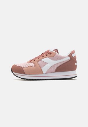 Scarpe atletiche rosa caratterizzate da una combinazione di materiali lisci e testurizzati, dettagli bianchi, chiusura con laccetti e suola in gomma nera.