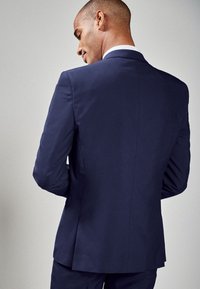Navy-Anzugjacke aus glattem Stoff, mit tailliertem Schnitt, strukturierten Schultern und einem Schlitzausschnitt hinten.