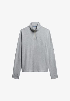 Suéter gris claro, hecho de una tela suave, con media cremallera y cuello alto. Incluye un pequeño logo en la zona del pecho.