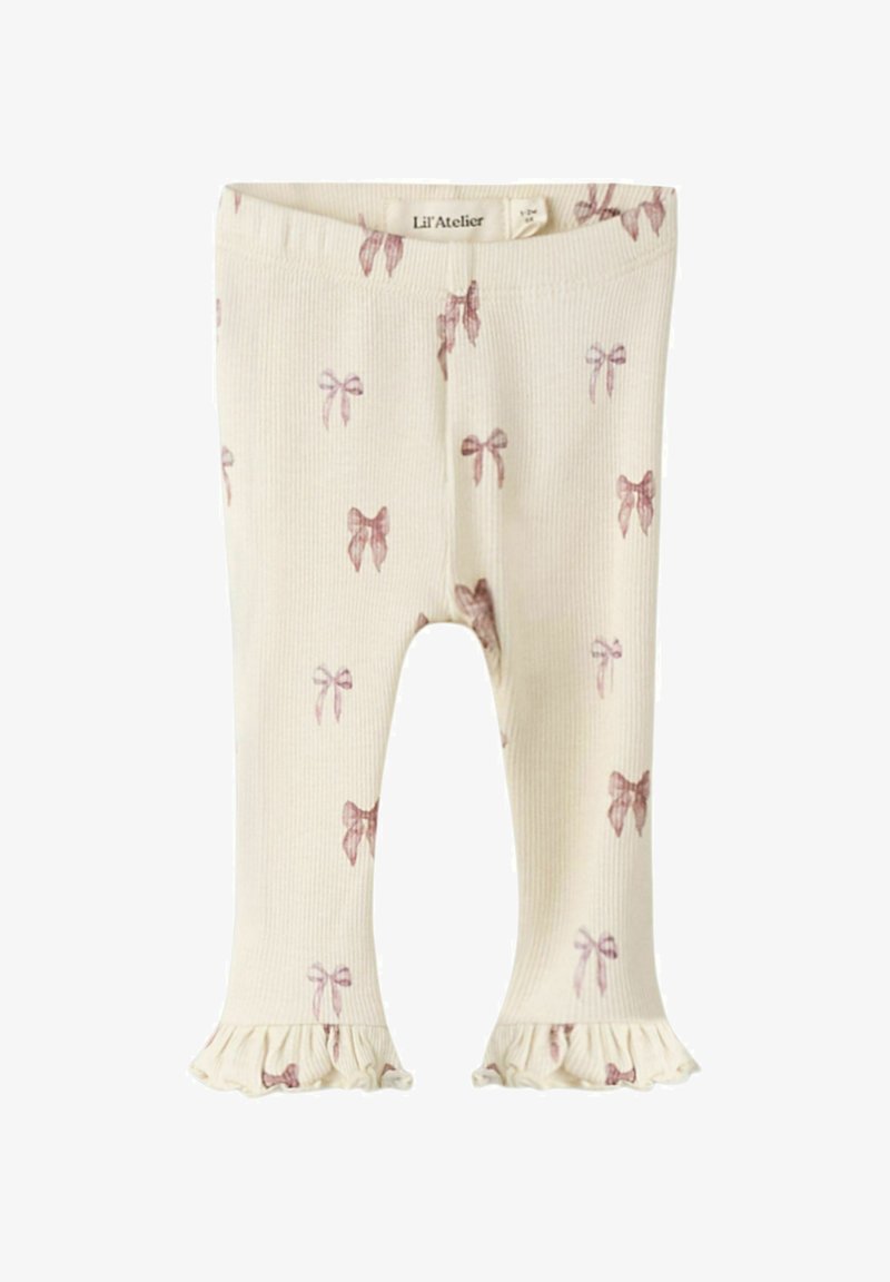 Leggings crème côtelés avec des motifs de nœuds roses et des poignets volantés. Fabriqués en matériau doux, adaptés pour une tenue décontractée.