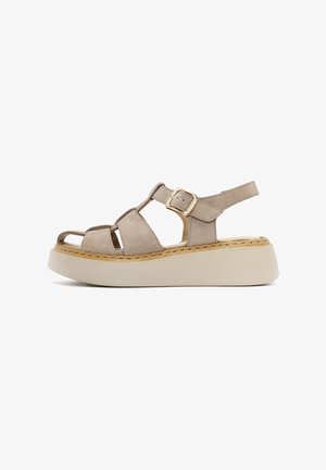 Beige suede platform sandals with adjustable ankle strap, open toe design, and contrasting beige sole; features stitched detailing and gold buckle.