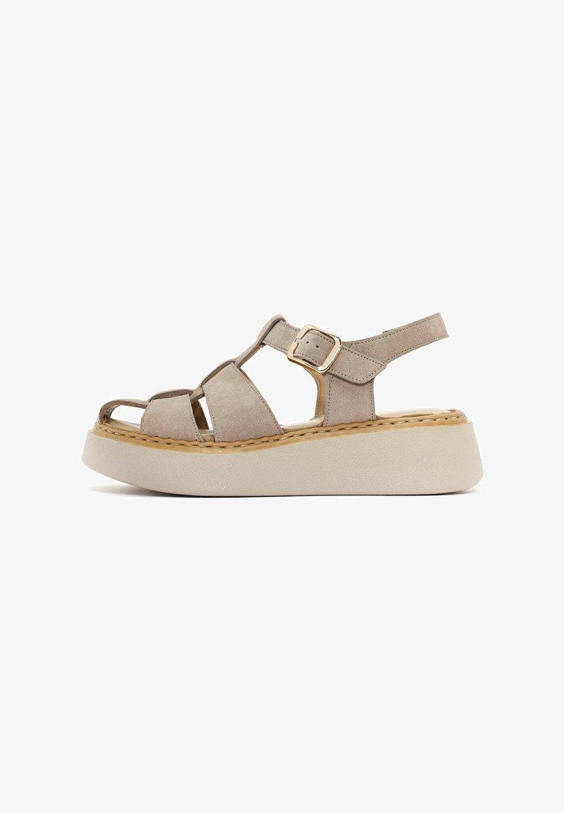 Beige suede platform sandals with adjustable ankle strap, open toe design, and contrasting beige sole; features stitched detailing and gold buckle.