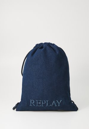 Sacca con coulisse realizzata in denim blu navy con una superficie testurizzata. "REPLAY" è ricamato in un blu più chiaro nella parte inferiore. Corde nere regolabili.