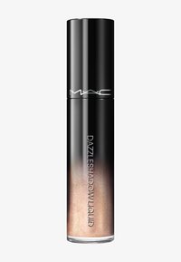 Sombra de ojos líquida Dazzleshadow de MAC en un tubo transparente y negro con brillo rosa dorado en el interior sobre un fondo blanco.