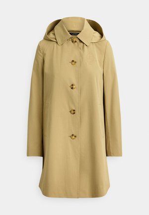 Imperméable beige avec capuche, fermeture à boutons et poches latérales. Comprend des boutons dorés et un logo brodé discret sur la poitrine.