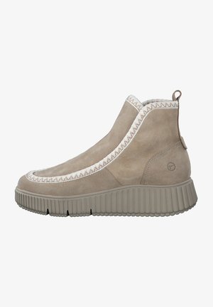 Taupe suede ankle boot with cream woven trim, ridged thick sole, and pull tab at the back, viewed from the outer side.