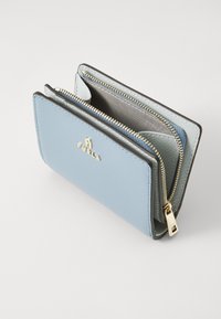 Blå lær lommebok med strukturert design, utstyrt med glidelås og hardware i gulltone. Innvendig har den kortlommer og en glidelåslomme.
