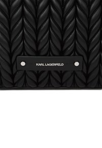 Sac en cuir noir matelassé avec un motif de feuilles en relief, quincaillerie noire robuste et une étiquette métallique portant l'inscription "KARL LAGERFELD."