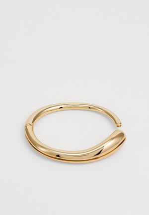 Gold-tone metal bangle with a smooth, curved design. Round edges, polished finish, and a seamless closure at one end.