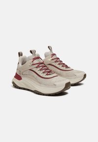 Scarpe da atletica in rete beige con dettagli bordò, colletto imbottito e suola testurizzata per una migliore aderenza. Presentano lacci tradizionali e un linguetta sul tallone.