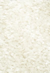 Λευκό ύφασμα διακοσμημένο με αλληλοεπικαλυπτόμενους κυκ λικούς παγιέτες, δημιουργώντας μία υφή με απαλή, λαμπερή εμφάνιση.