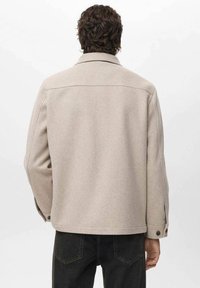 Beige wollen mix jas met een kraaghalslijn en knoopmanchetten, met een rechte snit en minimalistisch ontwerp.