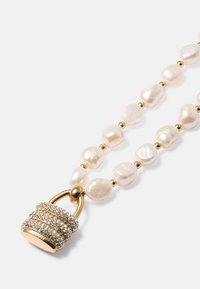 Necklace with irregular white pearls and small gold beads, featuring a gold-tone padlock pendant encrusted with clear crystals.