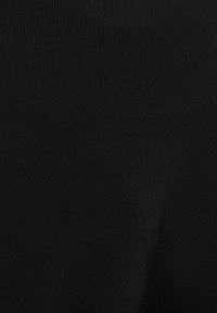 Leggings neri con una texture a coste, dotati di un alto punto vita. Realizzati in un materiale elastico, progettati per comfort e versatilità.