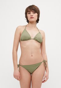 Bikini-set i olivgrön. Toppen har triangelformade kupor och knytband. Botten har sidoknytningar. Slät, elastisk tyg med minimal täckning.