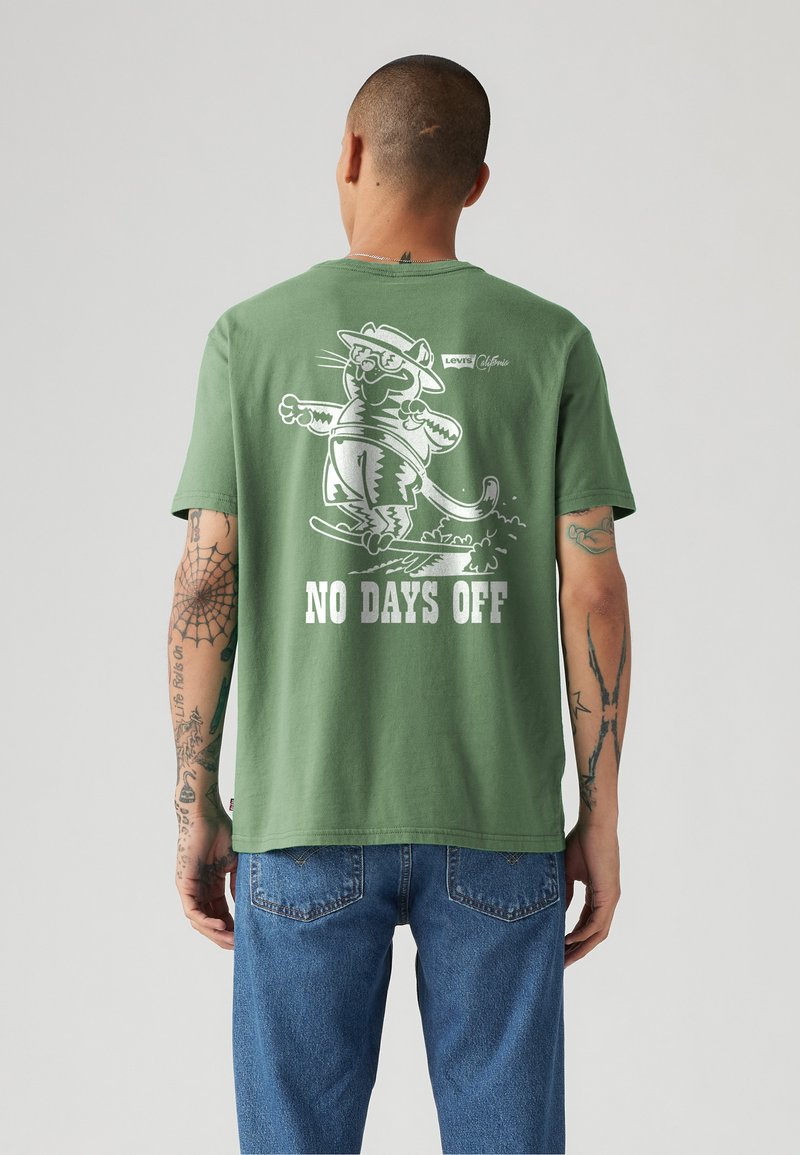 Zeleni pamučni T-shirt s grafikom crtanog mačka na skateboardu, s natpisom "NEMA DANA ODMORA" ispisanim ispod u bijeloj boji.
