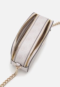 Harmaa kangasolkalaukku kullanvärisillä vetoketjuilla, jossa on kaksi lokeroa, ketjuhihna ja hienovarainen logokuvio edessä.