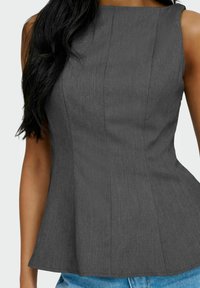 Grå, ærmeløs peplum top med en glat tekstur, der har lodrette sømme og en lige halsudskæring, båret sammen med denim.