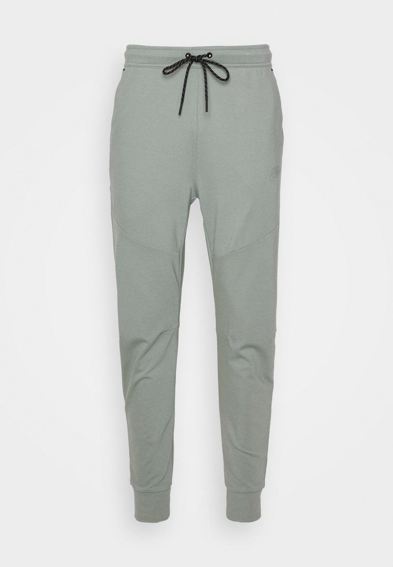 Pantalons de jogging gris clair en tissu doux, avec une taille élastique munie d'un cordon de serrage, des chevilles élastiquées et des accents de couture subtils.