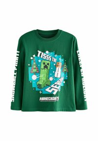 Hosszú ujjú zöld póló, 100% pamutból készült. Pixelált karaktergrafikával és "Ez az időszak" felirattal, valamint hópelyhekkel díszített.