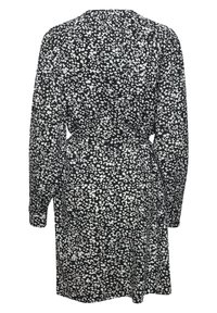 Robe noire à motif de points blancs irréguliers, manches longues et ceinture nouée à la taille, vue de dos.