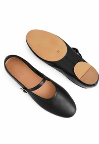 Svarta läderskor med rund tå och rem. Tan-inläggssula och slät yttersula. Storlek 37 markerad på botten. Platt klackdesign.