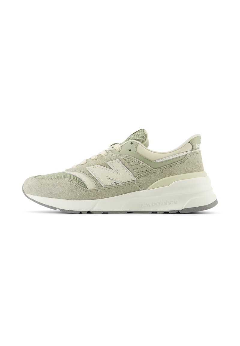 Sneaker New Balance beige e grigio chiaro con tomaia in suede e mesh, intersuola bianca, suola grigia e logo "N" sul lato.