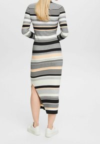 Robe midi en maille avec des rayures horizontales multicolores en noir, gris, blanc et pêche ; dotée d'une fente latérale et d'une silhouette ajustée.