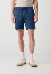 Shorts bleus à taille élastique avec cordon de serrage, dotés de poches latérales et d'une coupe droite, fabriqués en matériau léger.