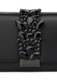 Czarna skórzana kopertówka z dużym, ozdobnym środkiem, zawierającym skomplikowane czarne kamienie szlachetne w różnych kształtach i rozmiarach, oraz metalową zawieszkę.