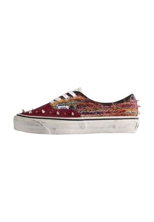 Sneaker Vans low-top con tessuto peloso multicolore, punta rossa, lacci bianchi, suola bianca e punte metalliche su punta e tallone.