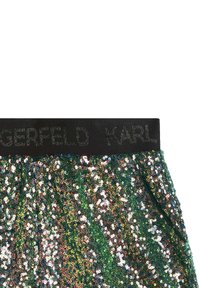 Shorts verdi con paillettes e una vita nera con marchio in rilievo. Le paillettes riflettono colori multipli, creando una texture scintillante.