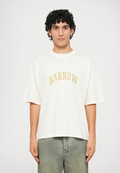 T-shirt bianca oversize con maniche corte, caratterizzata da un logo dorato "BARROW" in un design curvo sul petto. Realizzata in cotone.