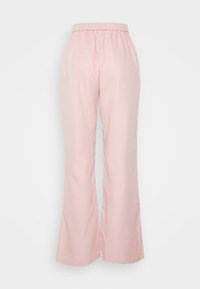Calças largas cor-de-rosa com um cós elástico, feitas de um tecido suave. Apresentam barra flare com fendas para um detalhe adicional.