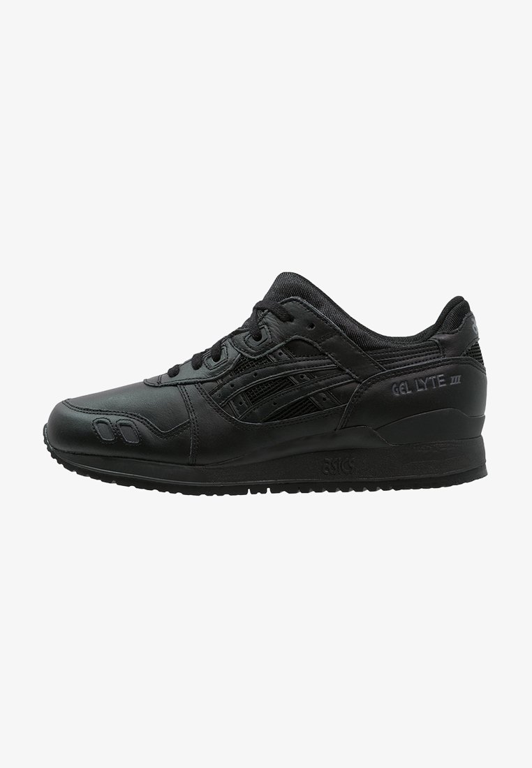 Baskets en cuir noir avec accents en mesh, bout arrondi, semelle plate et lacets noirs. Présente un marquage réfléchissant et un panneau distinct sur les côtés.