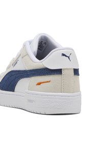 Sneaker bianco con accenti in camoscio blu navy, tallone testurizzato e logo arancione. Caratterizzato da suola in gomma solida e interno imbottito per il comfort.