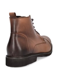 Brązowy skórzany botek za kostkę o gładkiej fakturze, okrągłym nosku i ciemnej gumowej podeszwie. Posiada oczka na sznurowadła oraz wykończenia szyte.