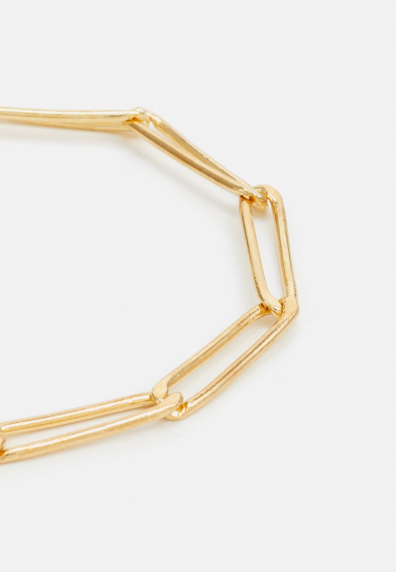 Goldfarbene Gliederkette aus Ovalen, strukturierten Gliedern mit einer polierten Oberfläche, die ein minimalistisches Design schafft.