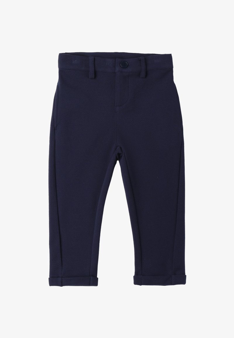 Granatowe spodnie dopasowane, uszyte z materiału o fakturze, z pojedynczym zapięciem na guzik, bocznymi kieszeniami oraz podwiniętymi nogawkami.