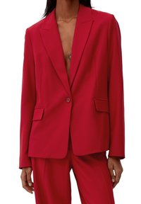 Blazer ajusté rouge avec revers crantés, fermeture à un bouton, deux poches avant et une texture de tissu lisse.