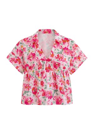 Blouse à manches courtes col en V avec motif floral rose, rouge et orange sur fond blanc.